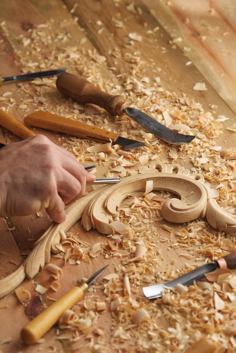 Atelier de menuiserie avec artisan sculptant un ornement décoratif en bois