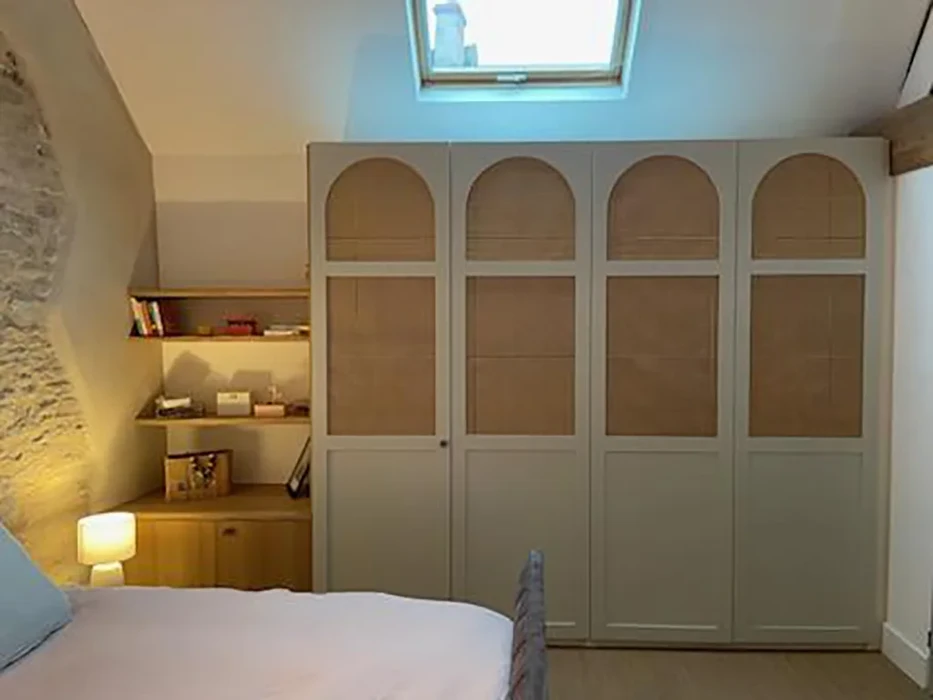 Chambre mansardée avec armoire sur-mesure à quatre portes vitrées et arcs cintrés