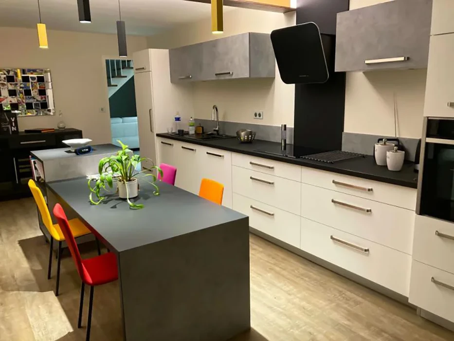 Cuisine moderne ouverte avec îlot central et chaises colorées multicolores