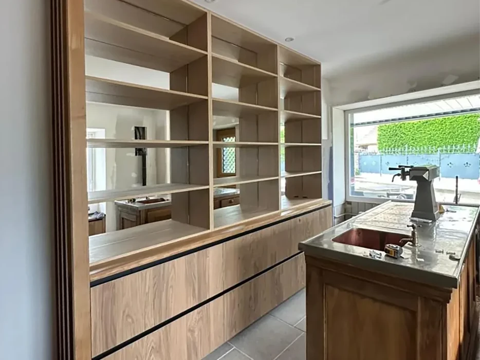 Cuisine moderne en bois clair avec îlot central, évier intégré et robinetterie noire