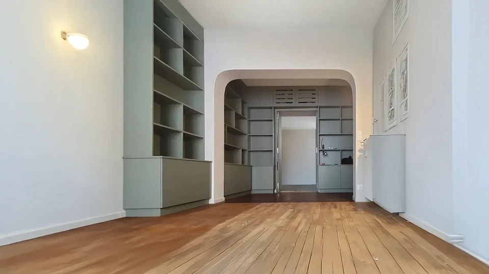 Intérieur d'atelier menuiserie avec établi en bois naturel, étagères murales compartimentées contenant outils et matériaux organisés