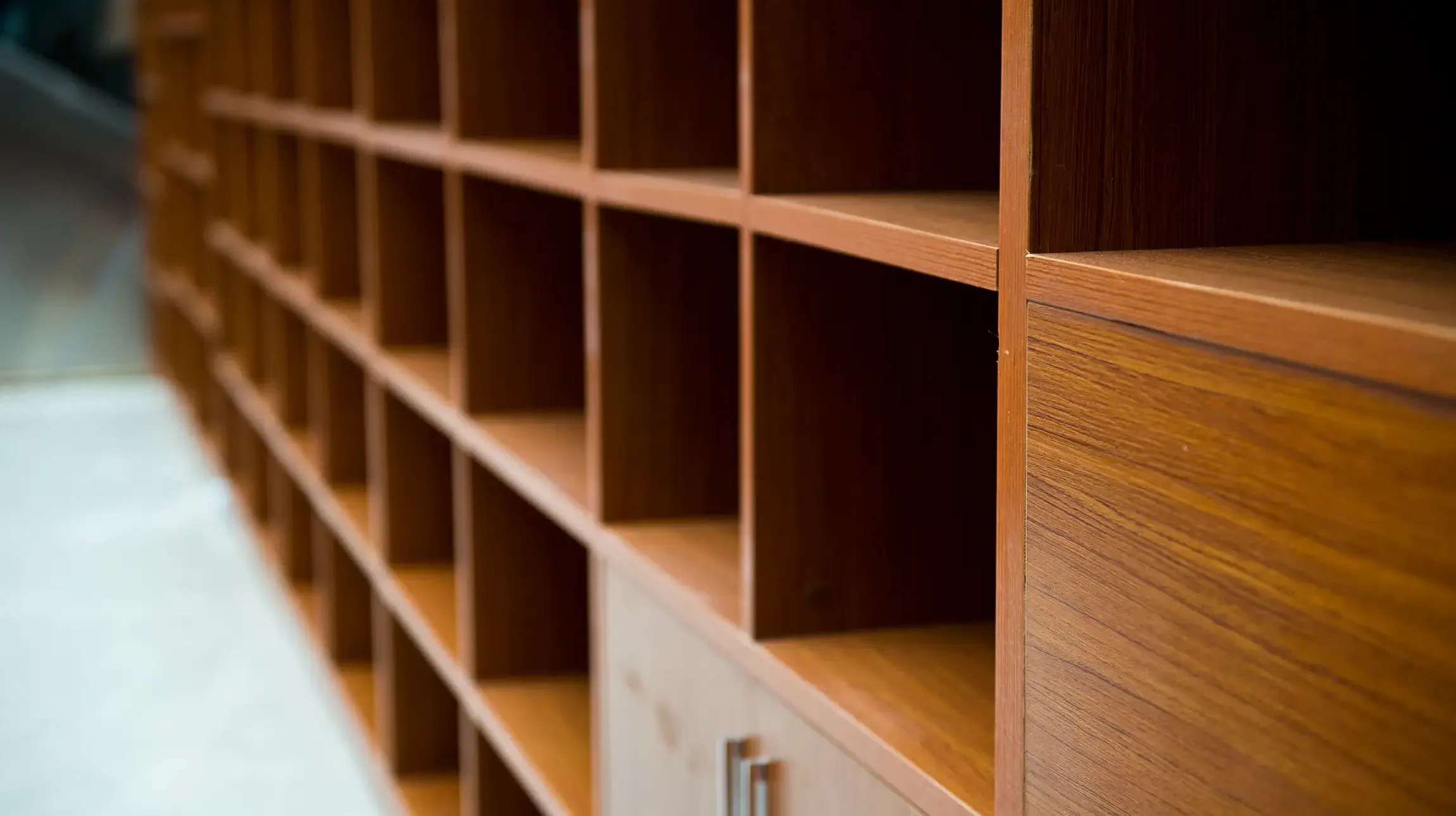 Salon moderne avec canapé gris, fauteuil et tables basses en bois clair
